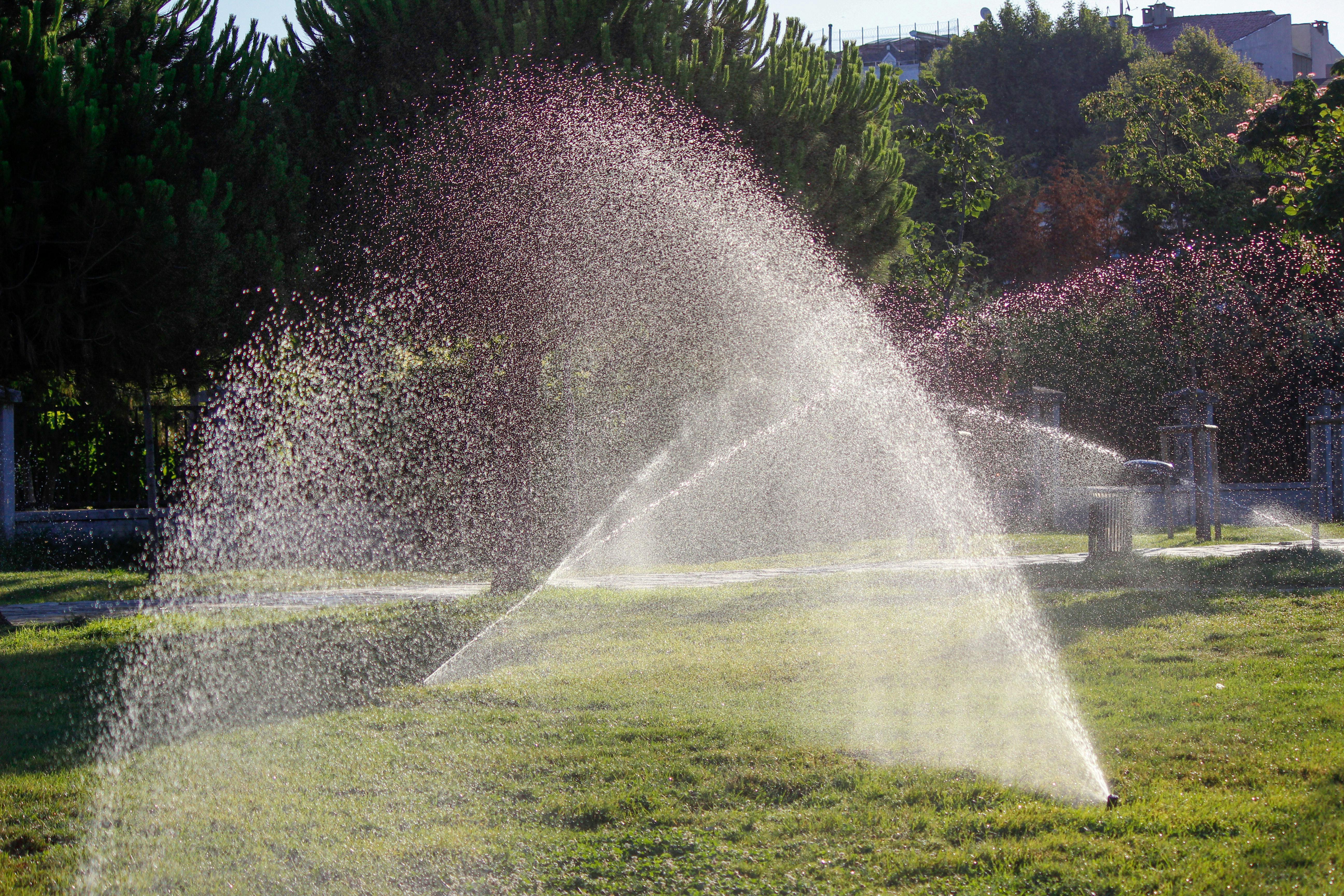 Sprinkler system watering a lush green lawn in Cedar City Utah